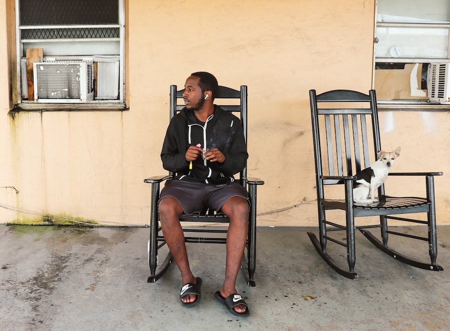 Isaiah Grimes and his dog sitting outside of his apartment in Miami. (Adam Mahoney/Capital B)