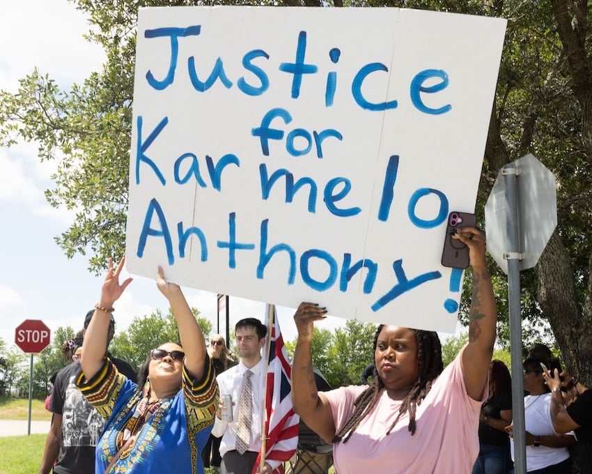 upporters of Karmelo Anthony block a man carrying a Grand Union flag outside of the Collin County Courthouse as Anthony's murder trial gets underway Thursday in McKinney, Texas. Anthony is accused of killing 17-year-old Austin Metcalf last April at a track meet. (Juan Figueroa/The Dallas Morning News via Getty Images)